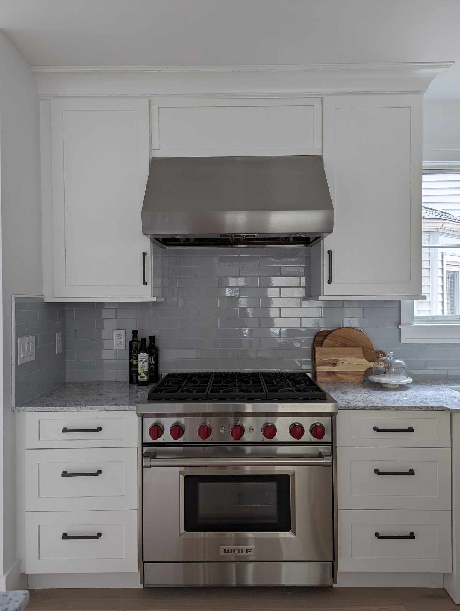 A kitchen with stainless steel appliances and white cabinets.