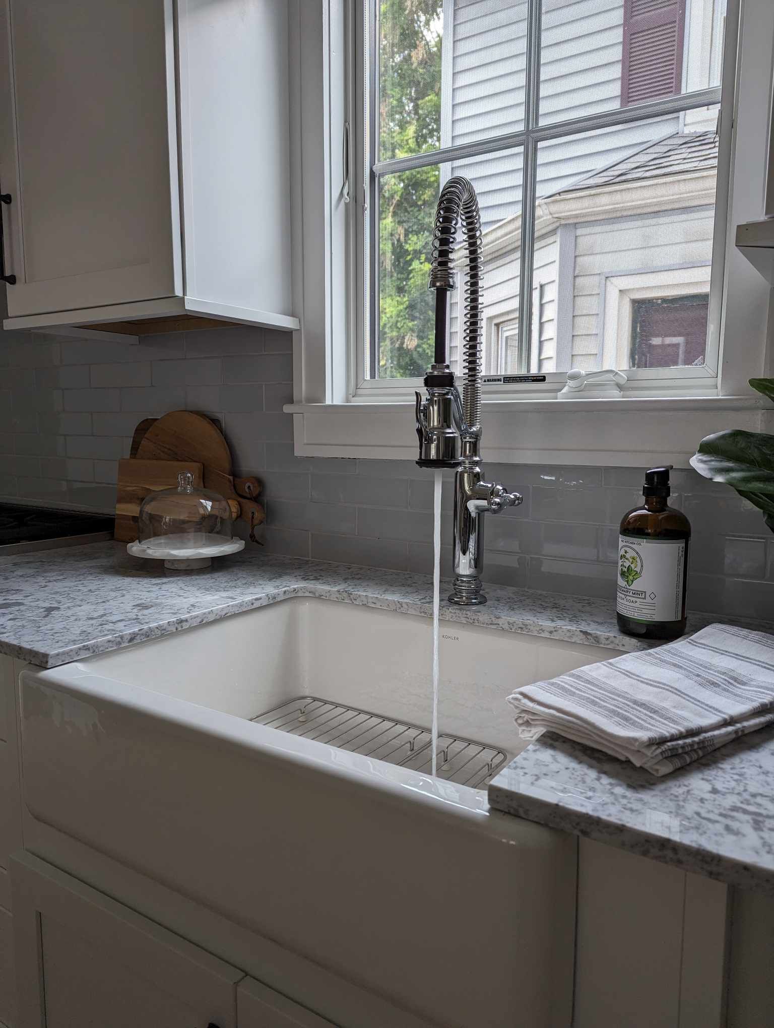 A kitchen sink with water running from the faucet.