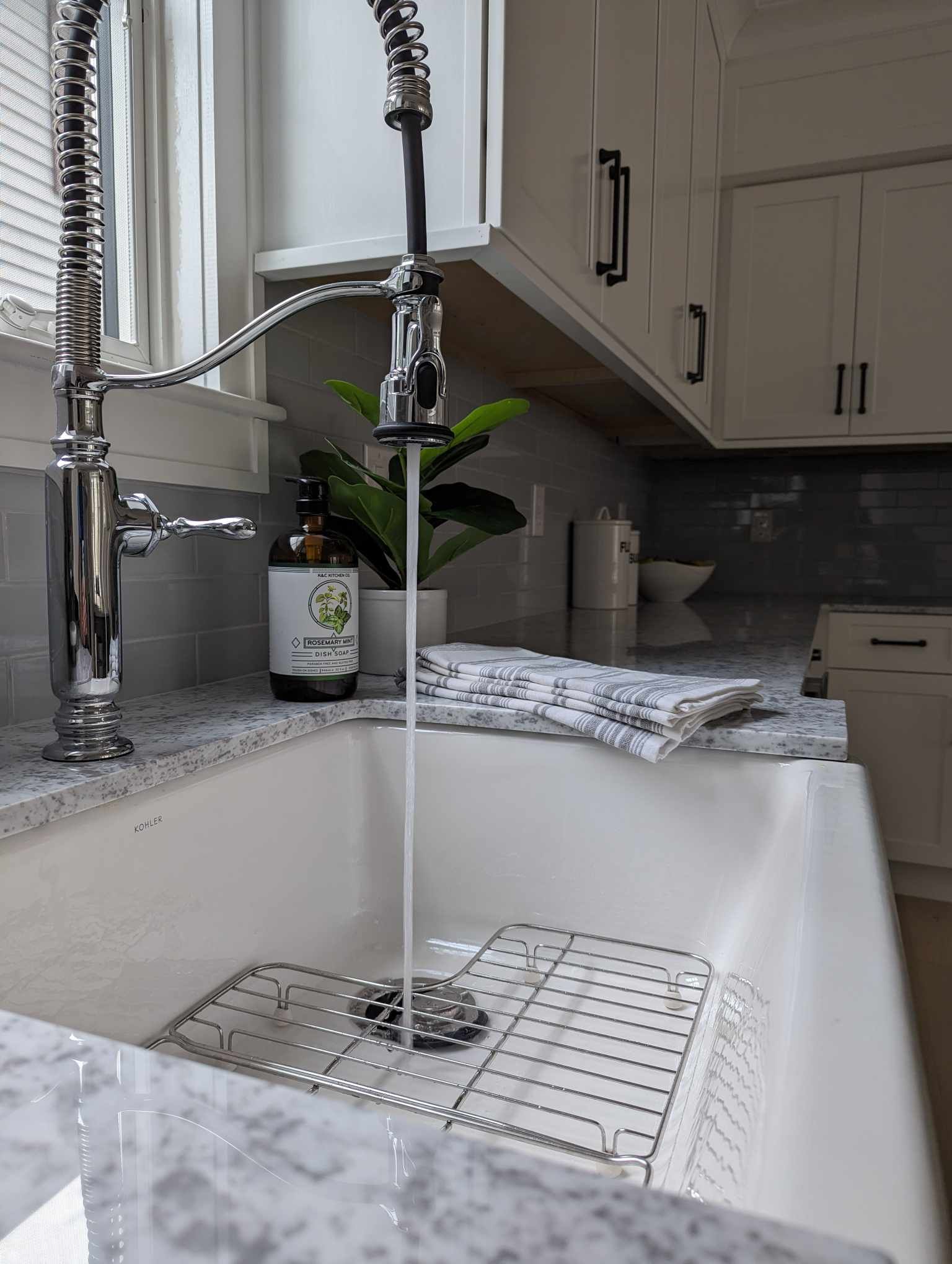 A kitchen sink with water running from the faucet.