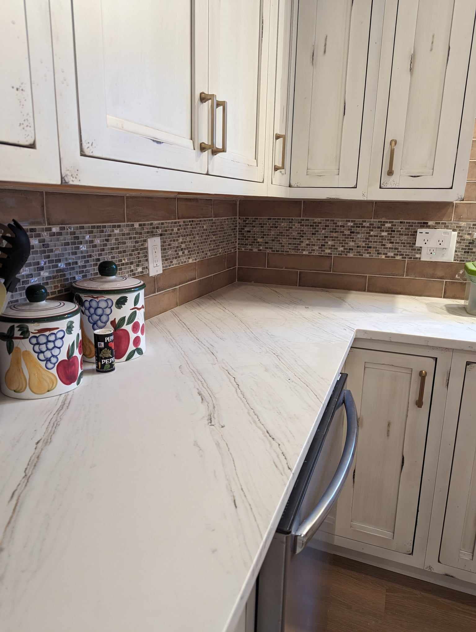 A kitchen with white cabinets and a white counter top.