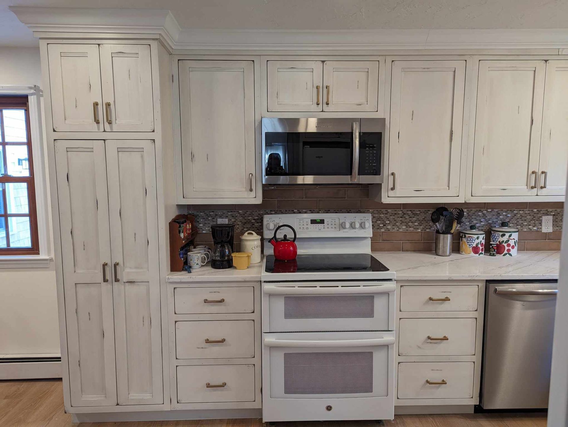 A kitchen with white cabinets and stainless steel appliances