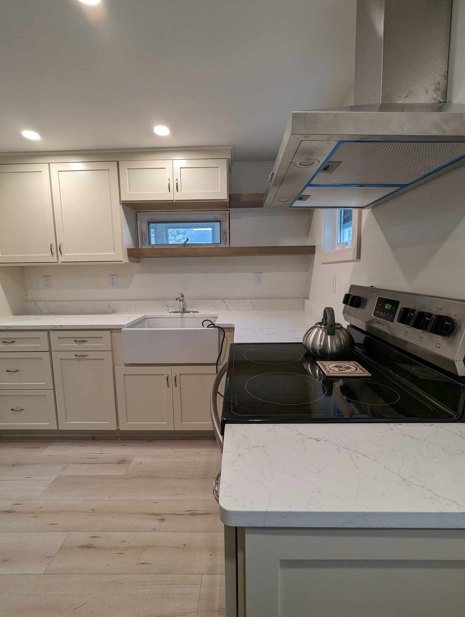 kitchen with white cabinets, a black stove top oven, and a sink.
