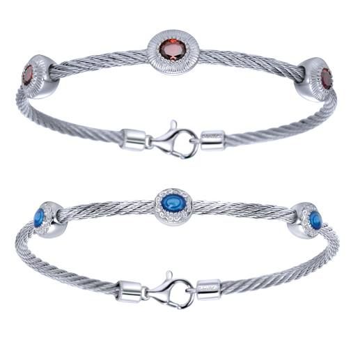 Two silver bracelets with gemstone accents, red and blue, on a twisted cable.