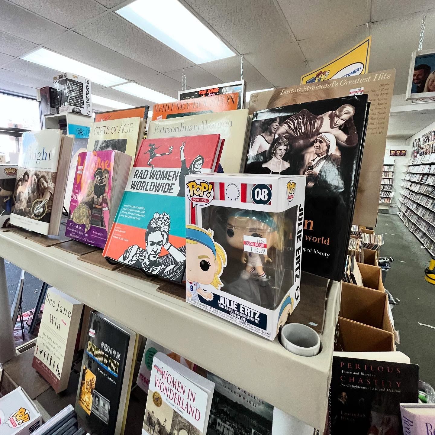 A shelf filled with books and a funko pop