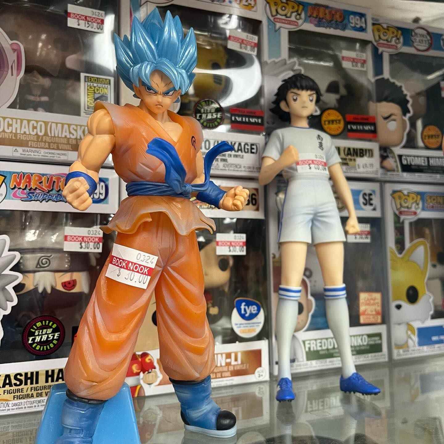 A display of funko pop figures including goku and a girl