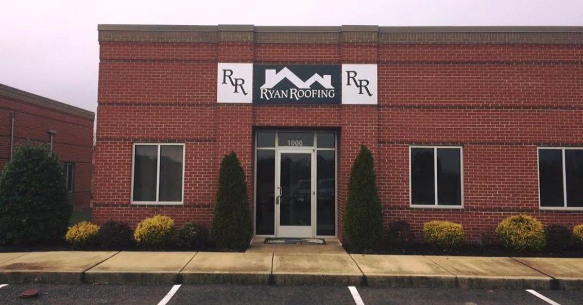Brick office building entrance with RR signs, central glass door, and two windows on each side.