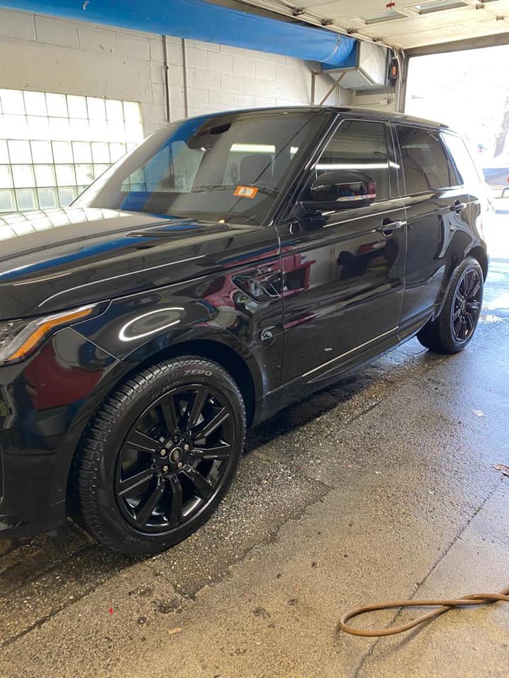 A black range rover sport is parked in a garage.