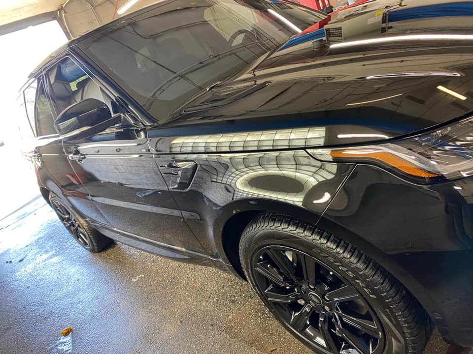 A black range rover sport is parked in a garage.