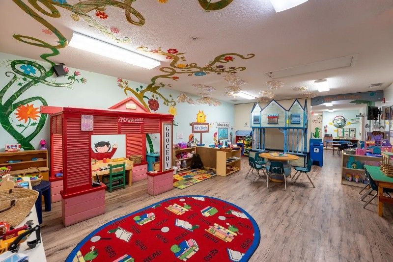 A large room filled with lots of toys and tables and chairs.