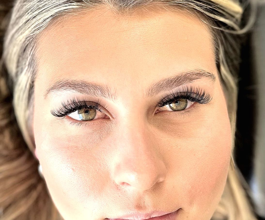 A close up of a woman 's face with long eyelashes.