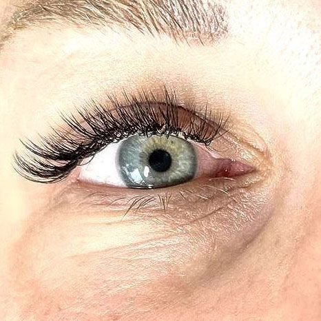 A close up of a woman 's eye with long eyelashes.