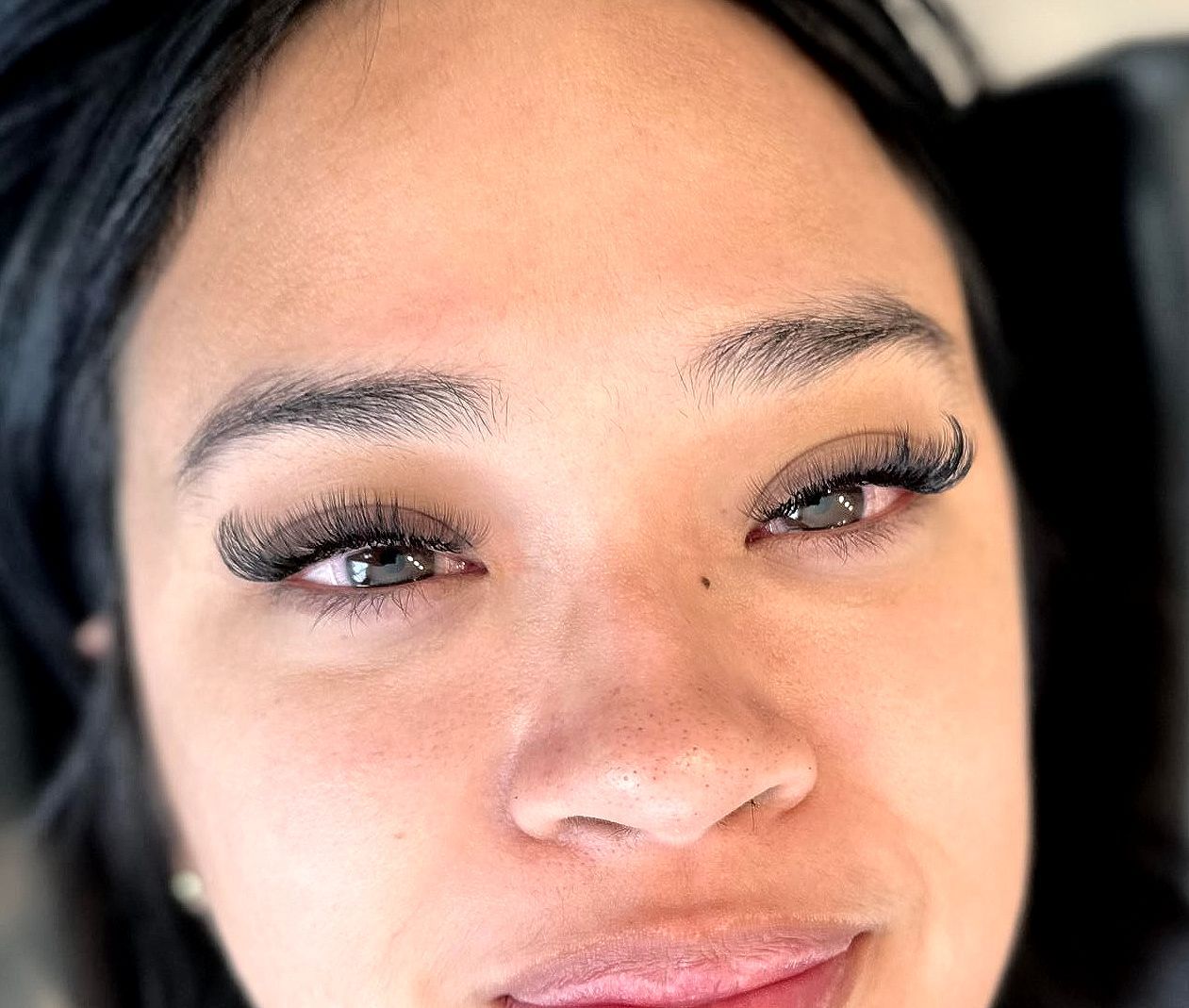A close up of a woman 's face with long eyelashes.