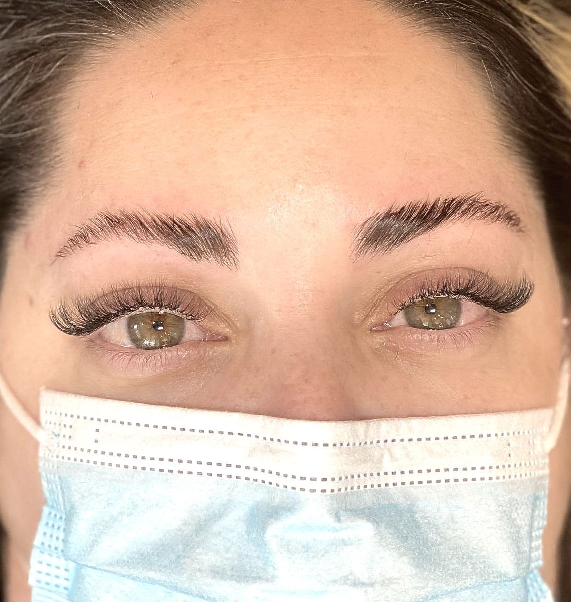 A close up of a woman wearing a face mask