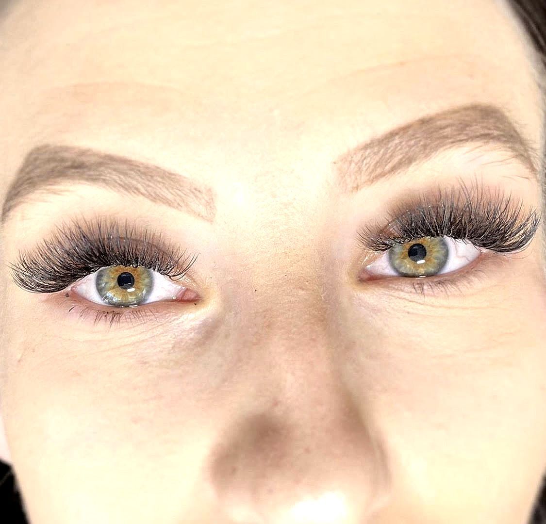 A close up of a woman 's eyes with long eyelashes.