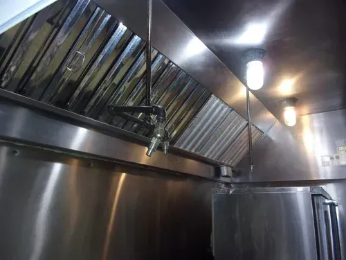 Stainless steel commercial kitchen exhaust hood and vents with lights overhead