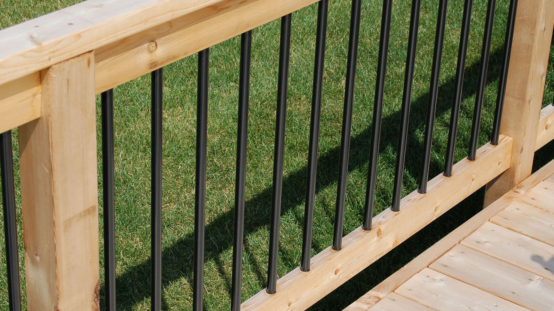 A close up of a wooden deck with a metal railing.