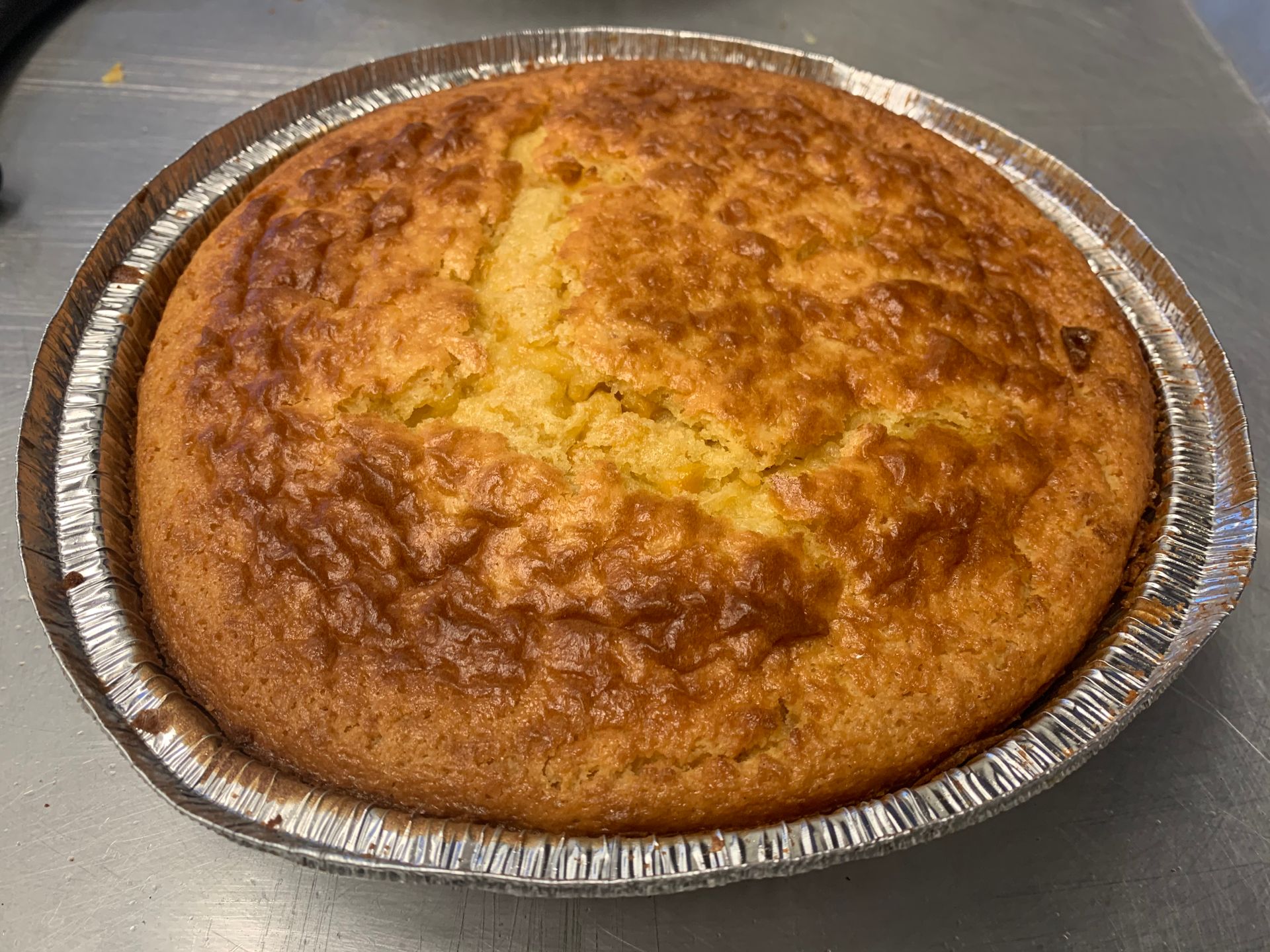 A pie in a tin foil pan on a table.