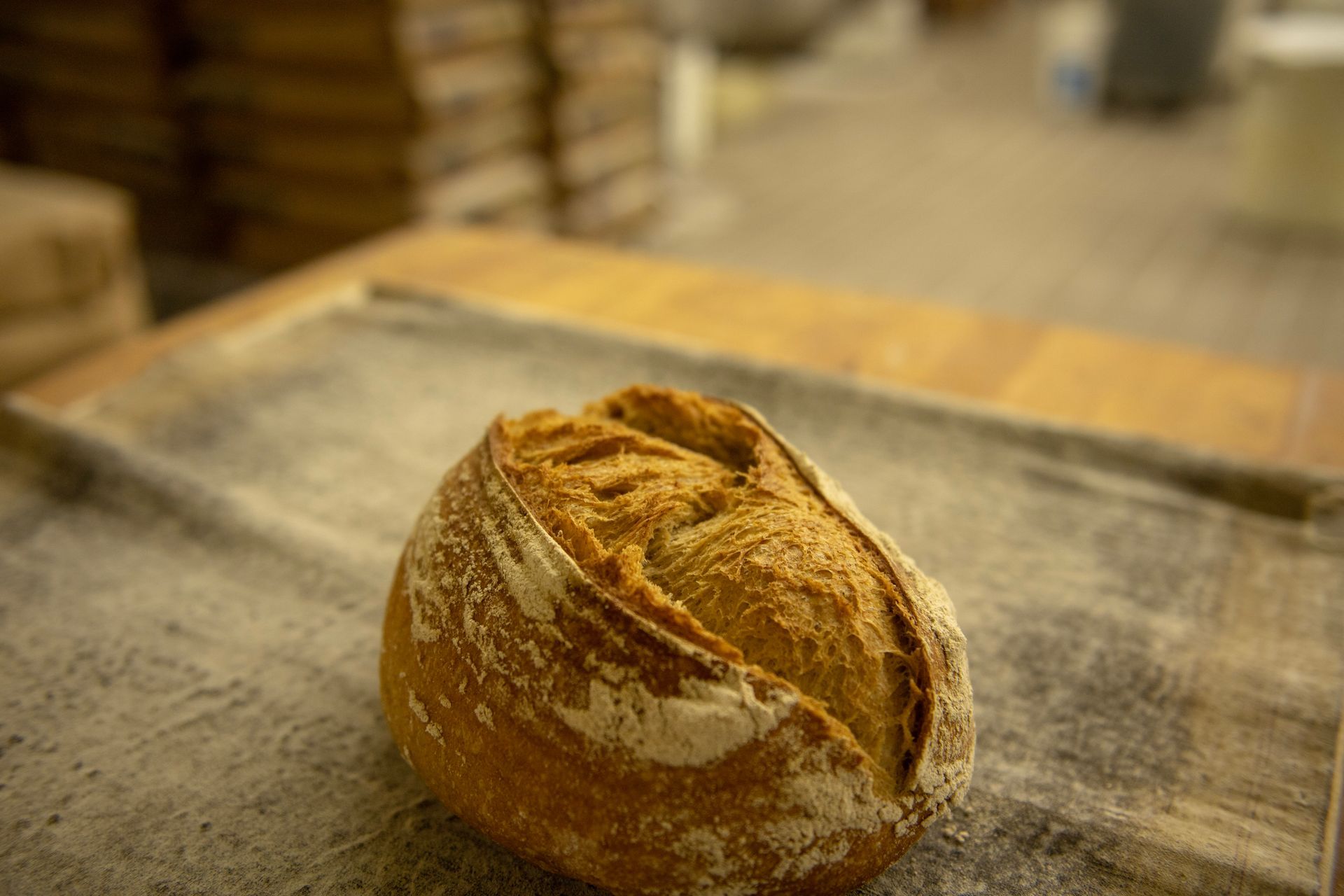 A loaf of bread is sitting on a table in a bakery.