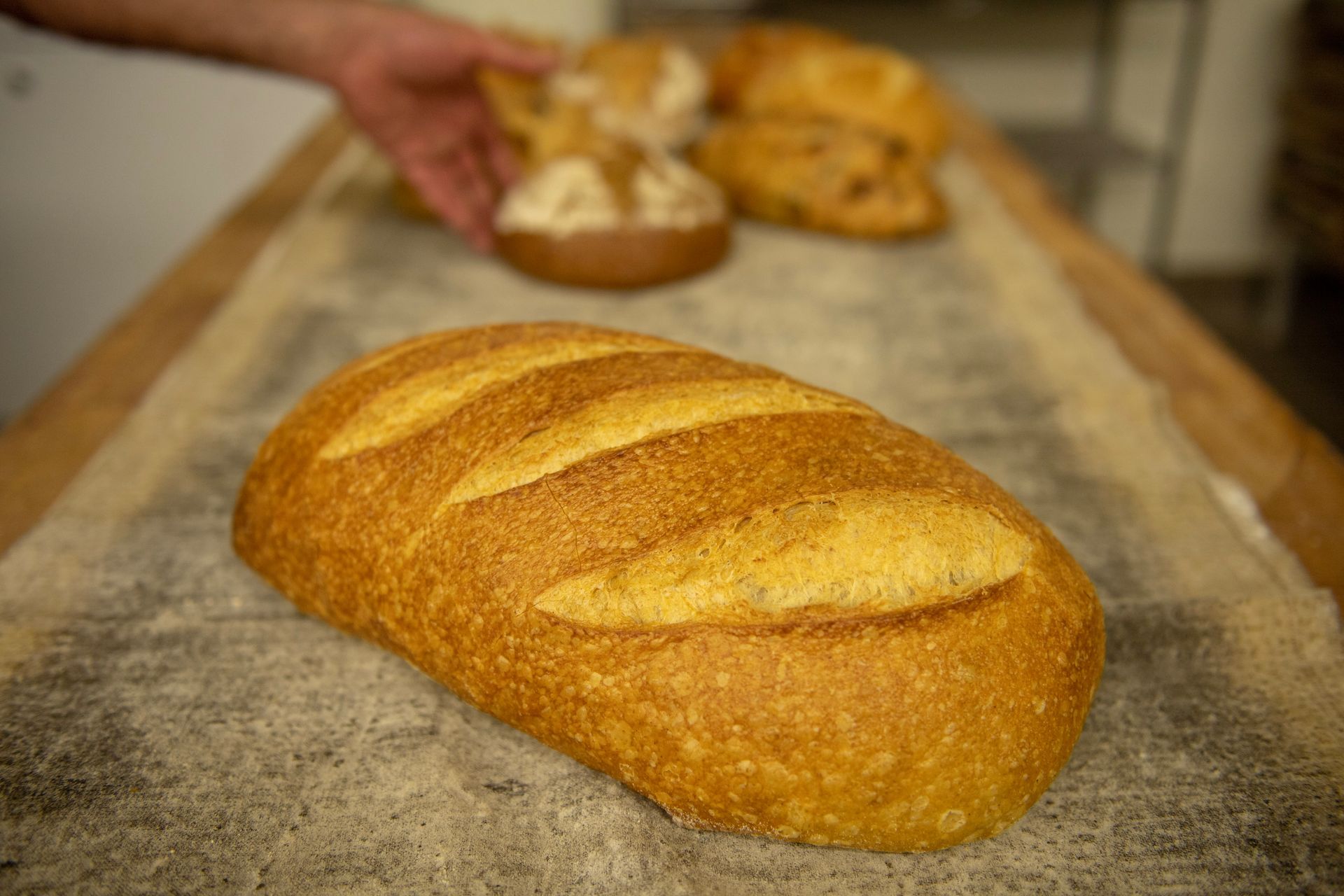 A loaf of bread is sitting on top of a wooden table.
