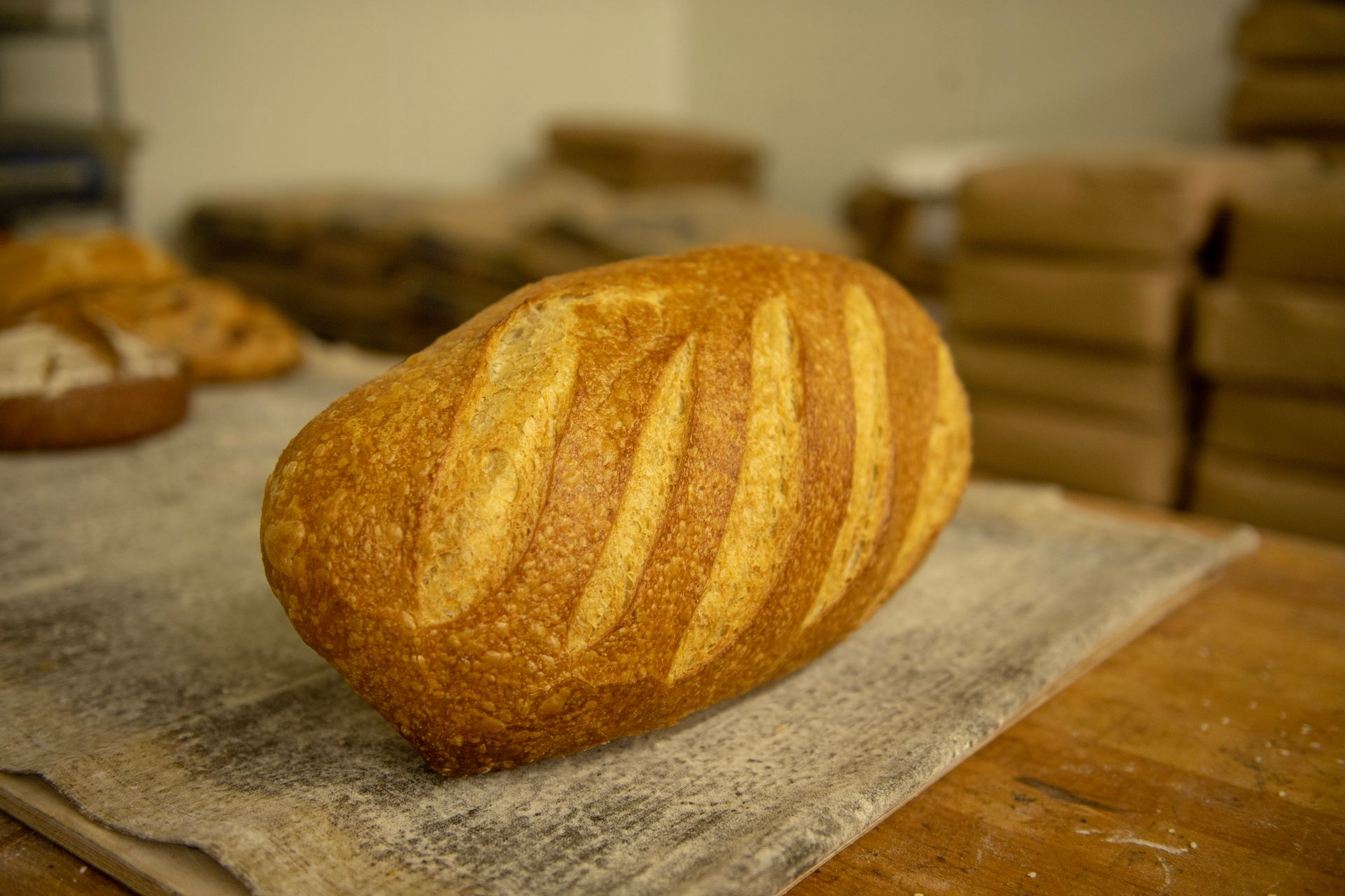A loaf of bread is sitting on a wooden table.