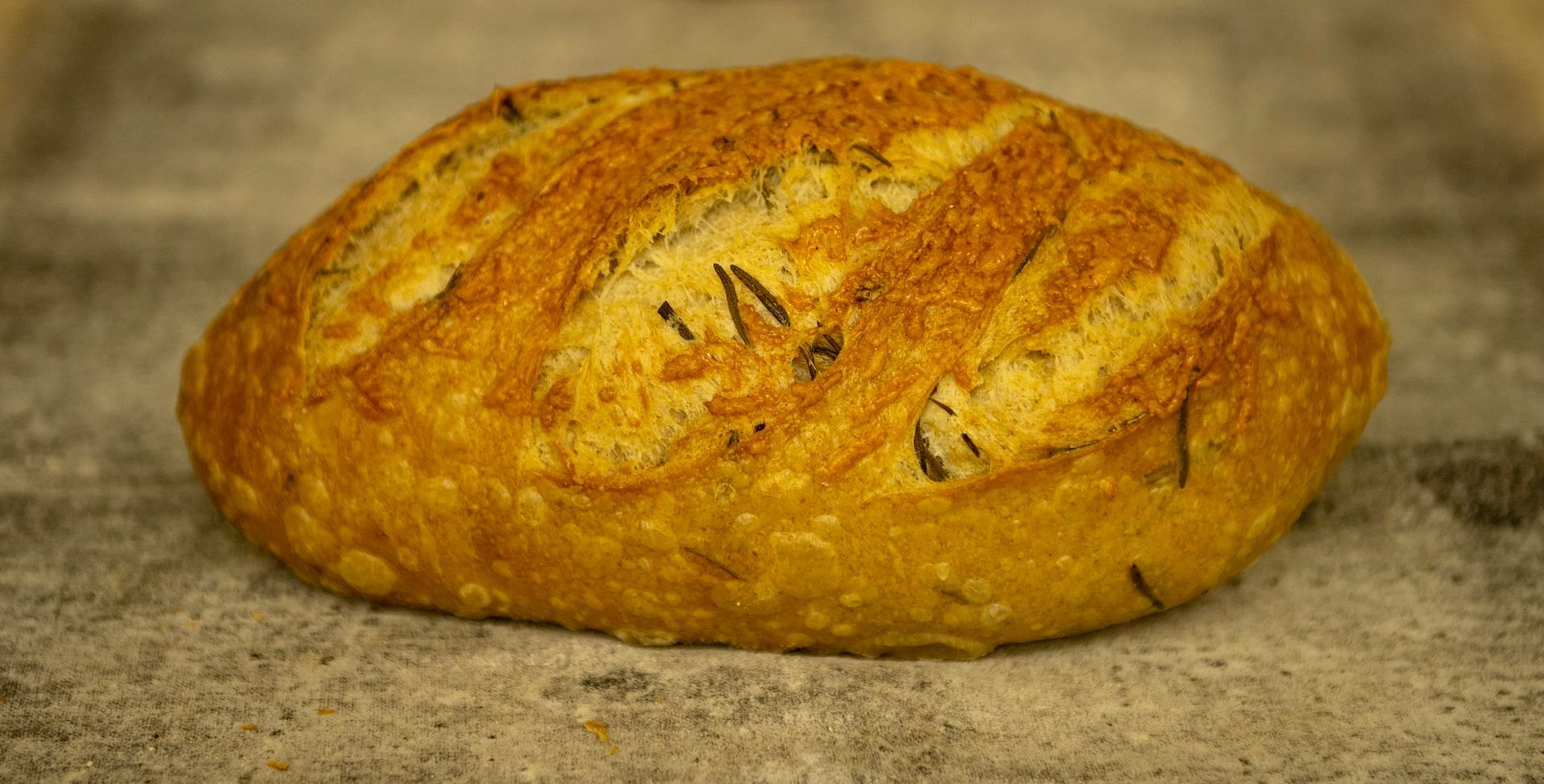 A loaf of bread is sitting on a table covered in flour.