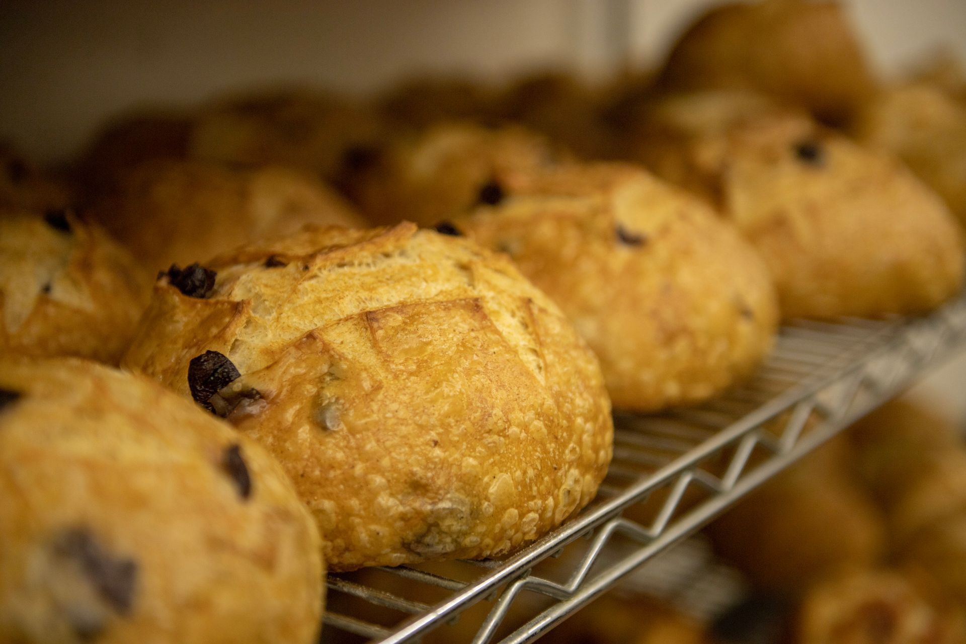 A bunch of muffins are sitting on a wire rack.
