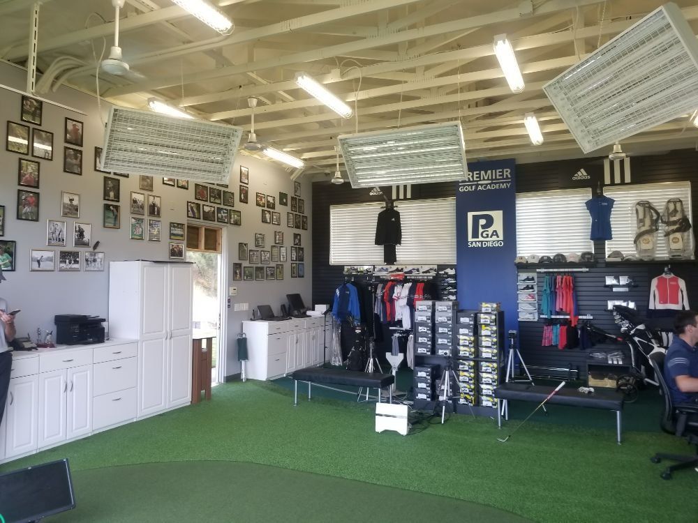 Indoor sports apparel store, green turf floor, white cabinets and ceiling, merchandise displays.