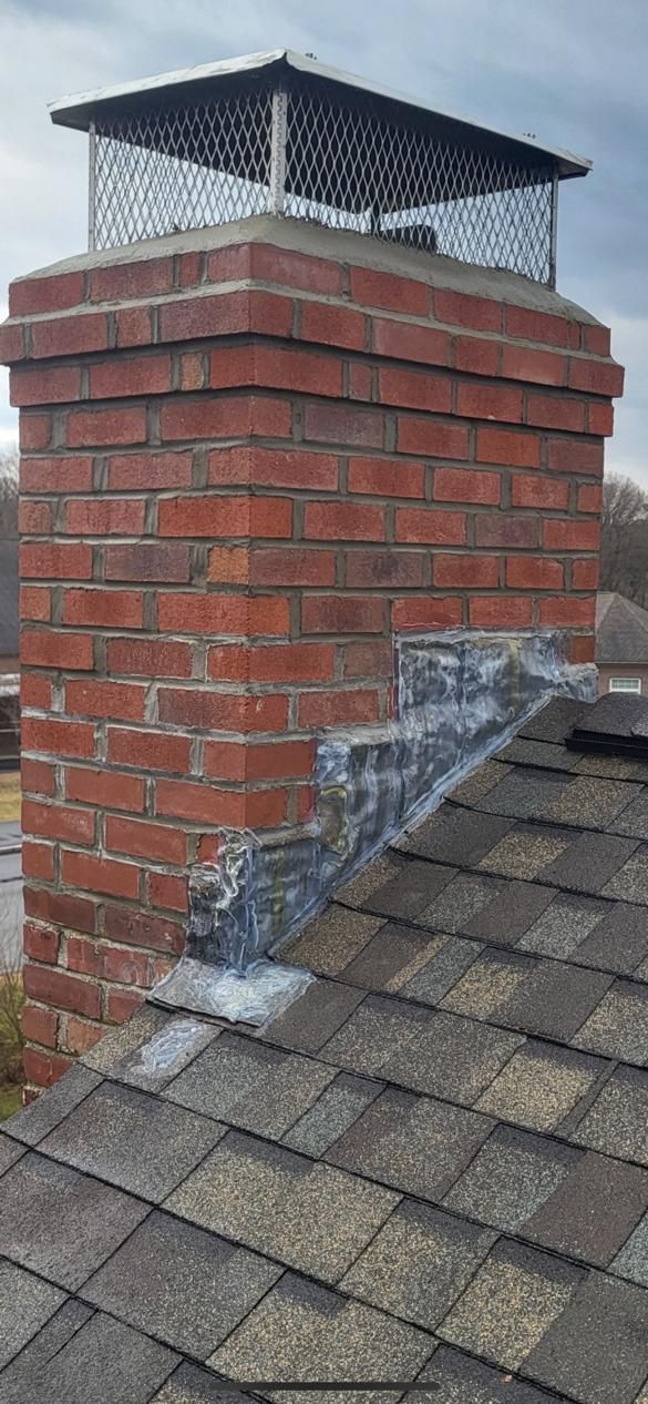A brick chimney is sitting on top of a roof.