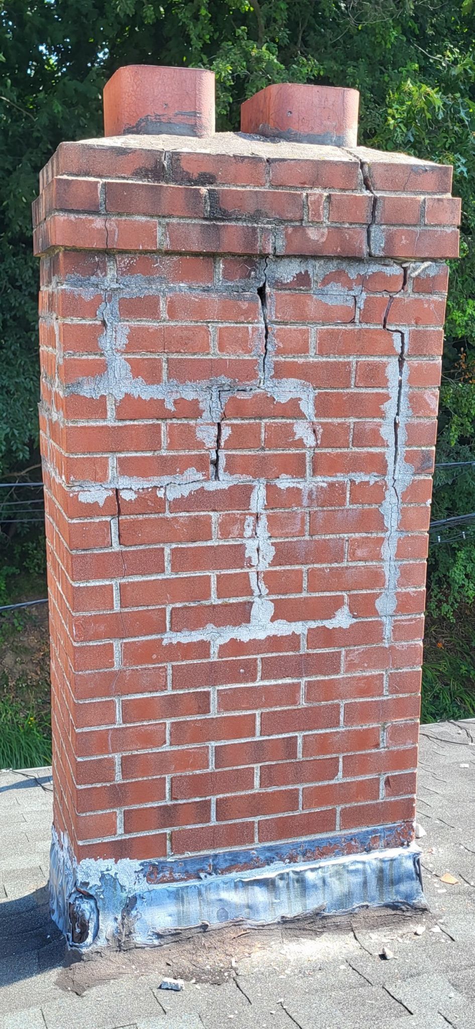 A brick chimney is sitting on top of a roof.