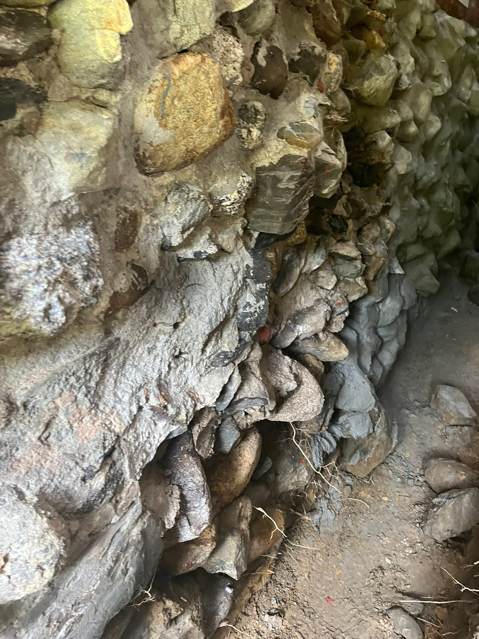 A close up of a rock wall with a lot of rocks on it.