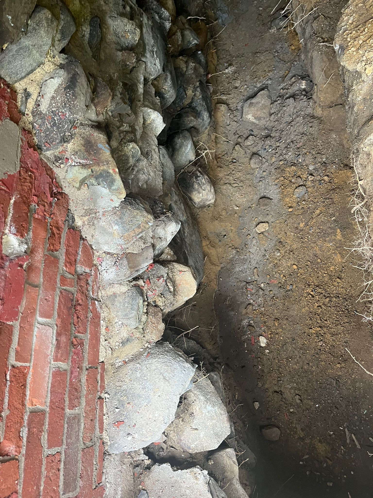 A close up of a rock wall next to a brick wall.