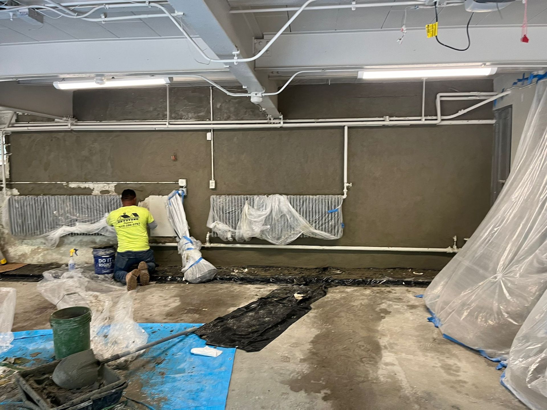 A man is working on a wall in a building.
