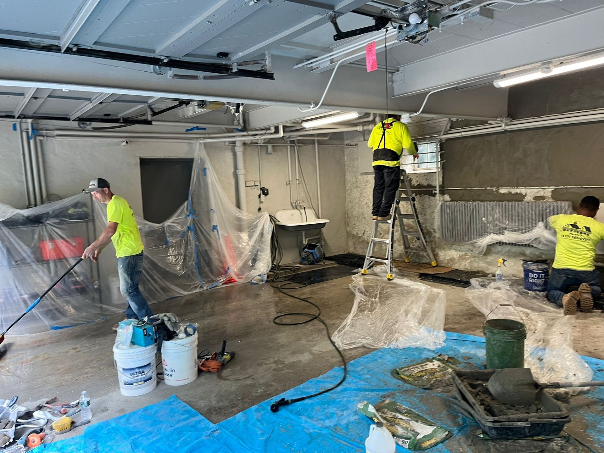 A group of men are working on a building in a garage.