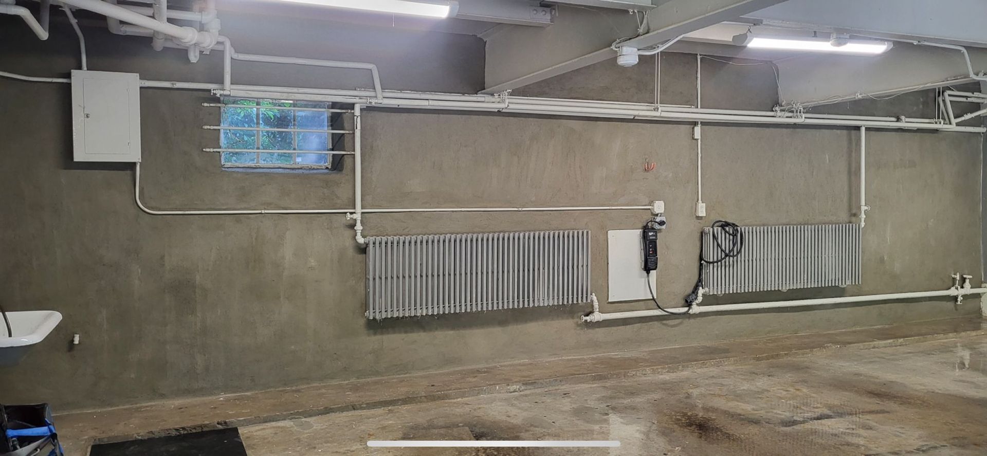 A room with a lot of pipes hanging from the ceiling.