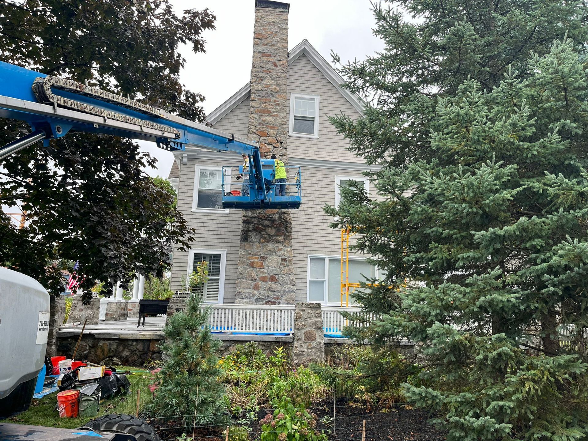 A man is cleaning a chimney on the side of a house