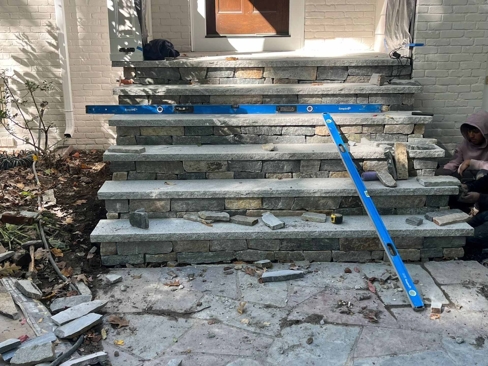 A person is working on a set of stairs in front of a house