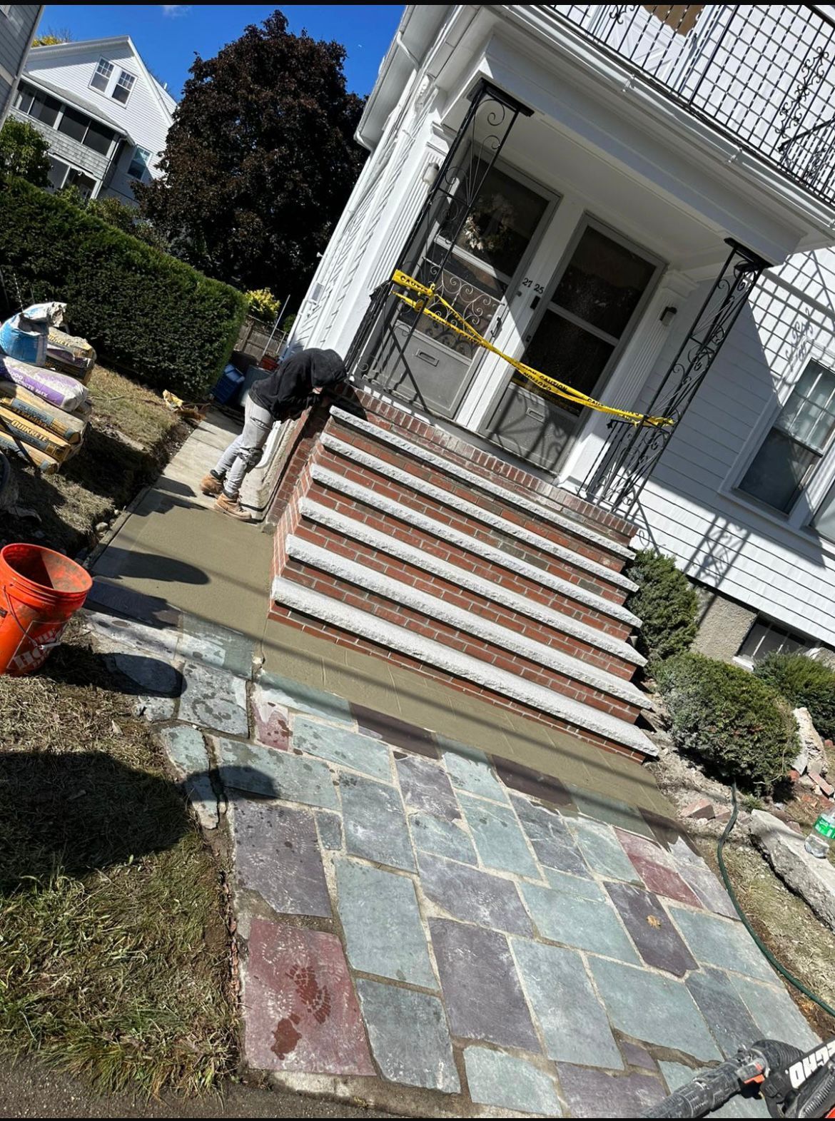 A man is working on the steps of a house
