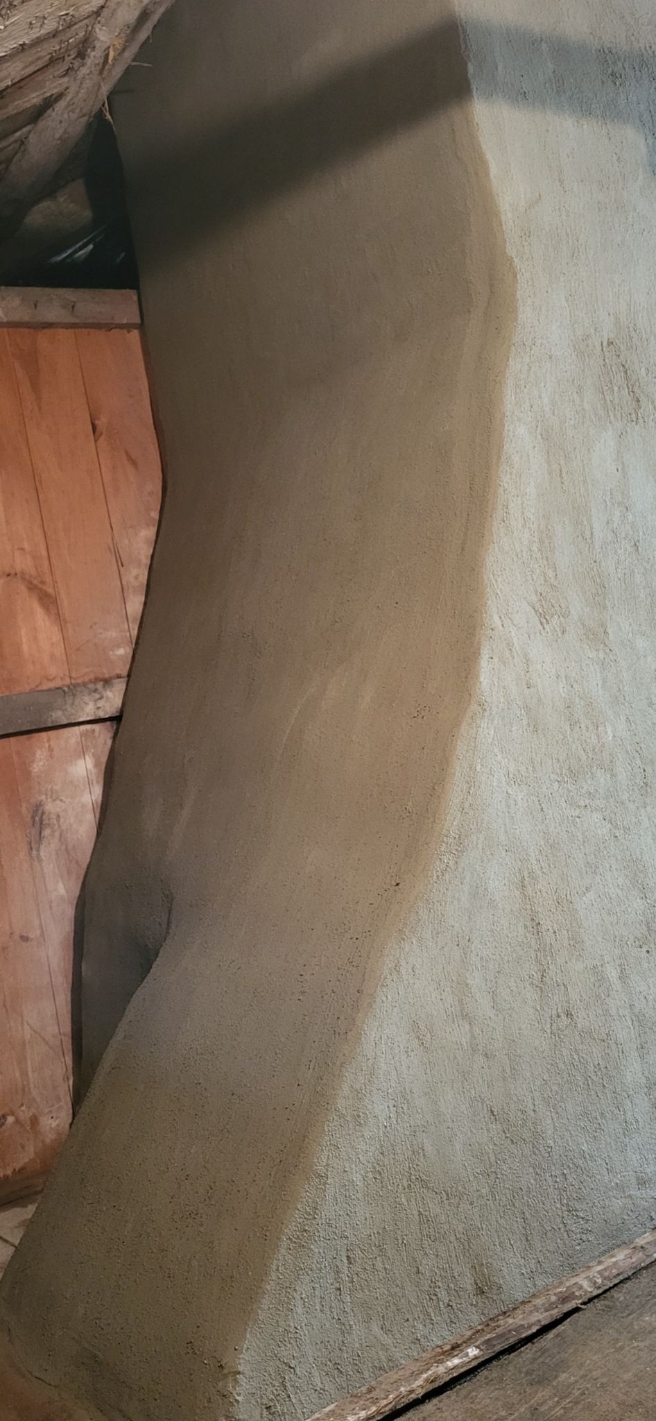 A close up of a carpet on a floor next to a brick wall