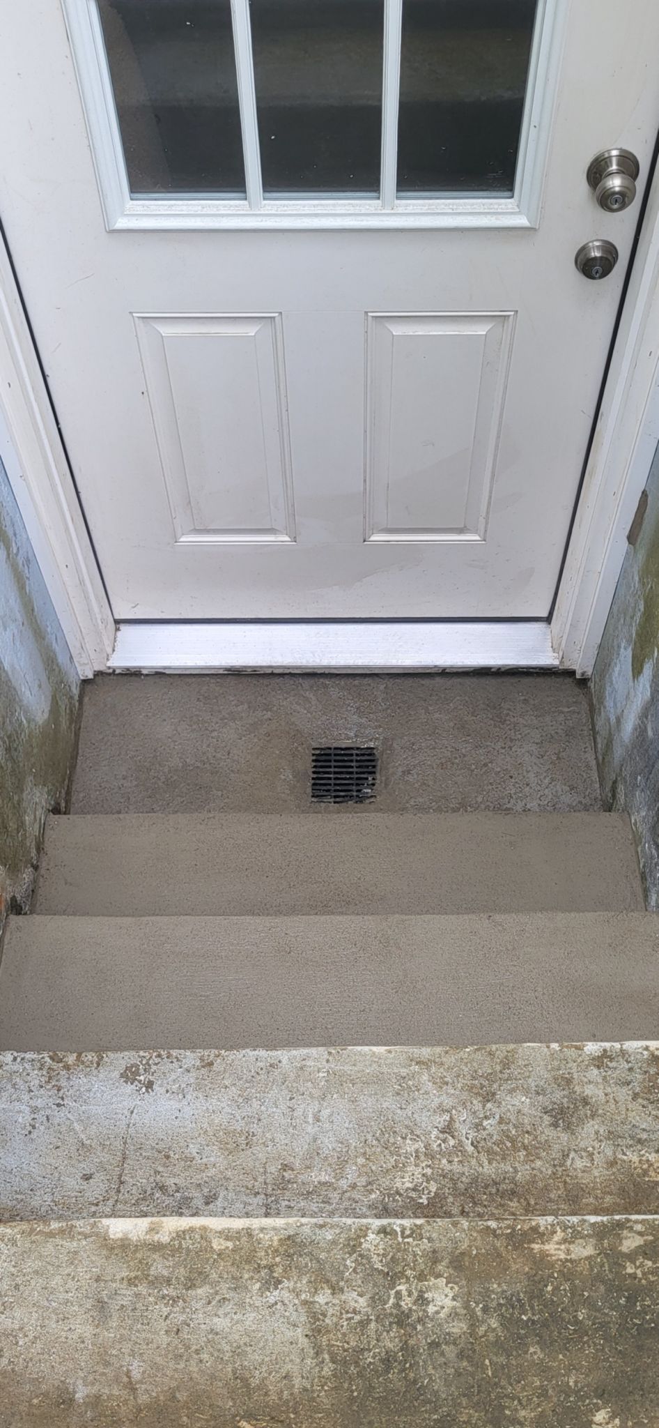 A white door is sitting on top of a set of stairs