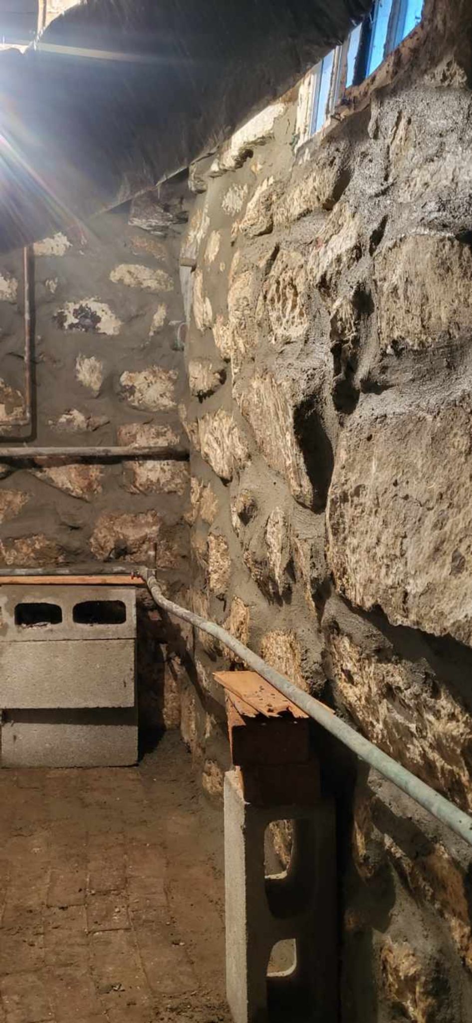 A room with a stone wall and a window