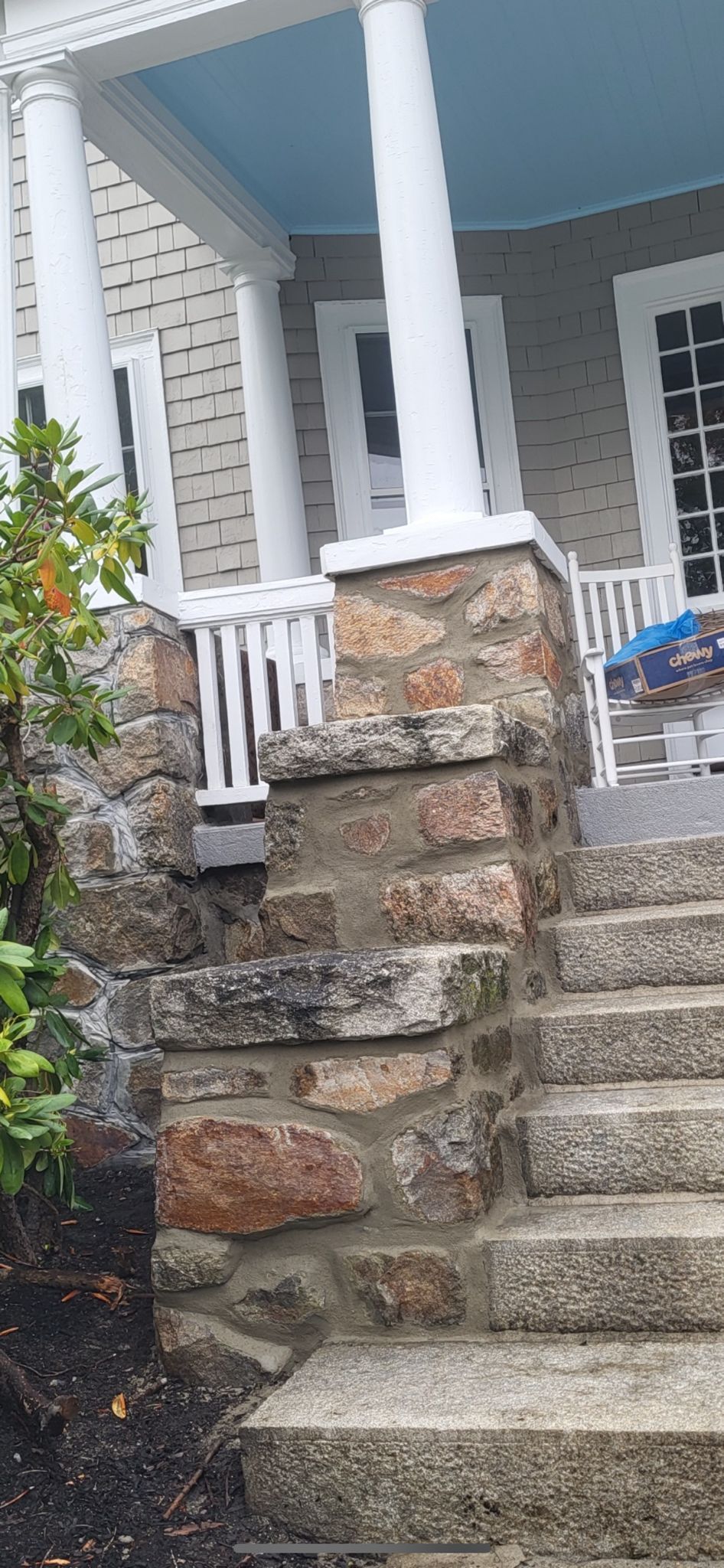 A stone staircase leading up to a porch of a house
