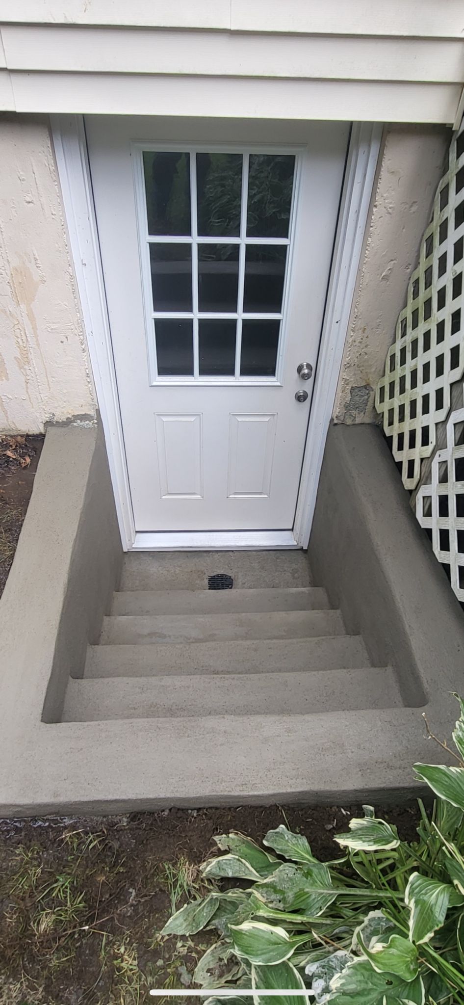 A white door with a window and stairs leading up to it
