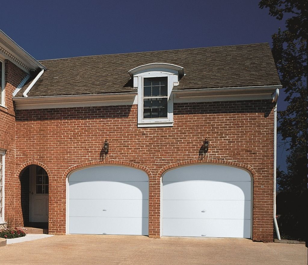 A large brick house with two white garage doors