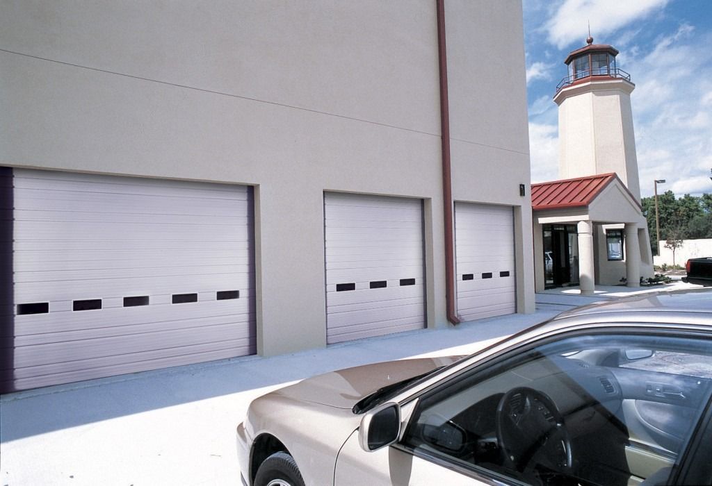 A car is parked in front of a building with a lighthouse in the background
