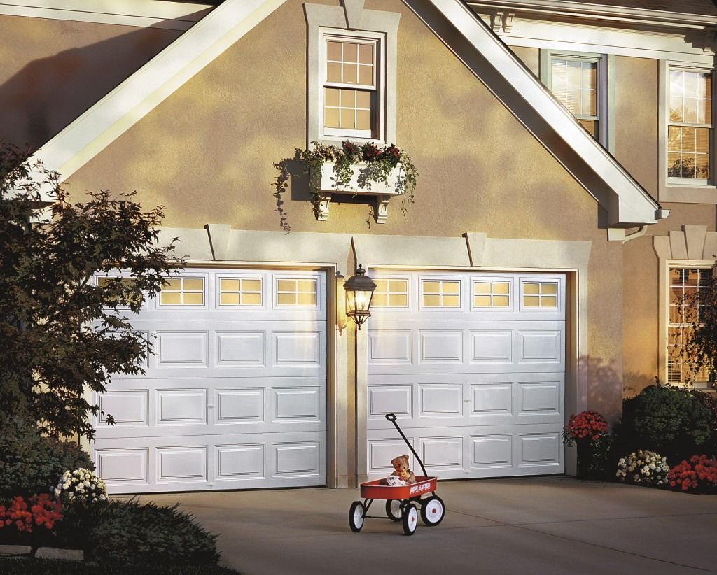 A red wagon is parked in front of a garage door
