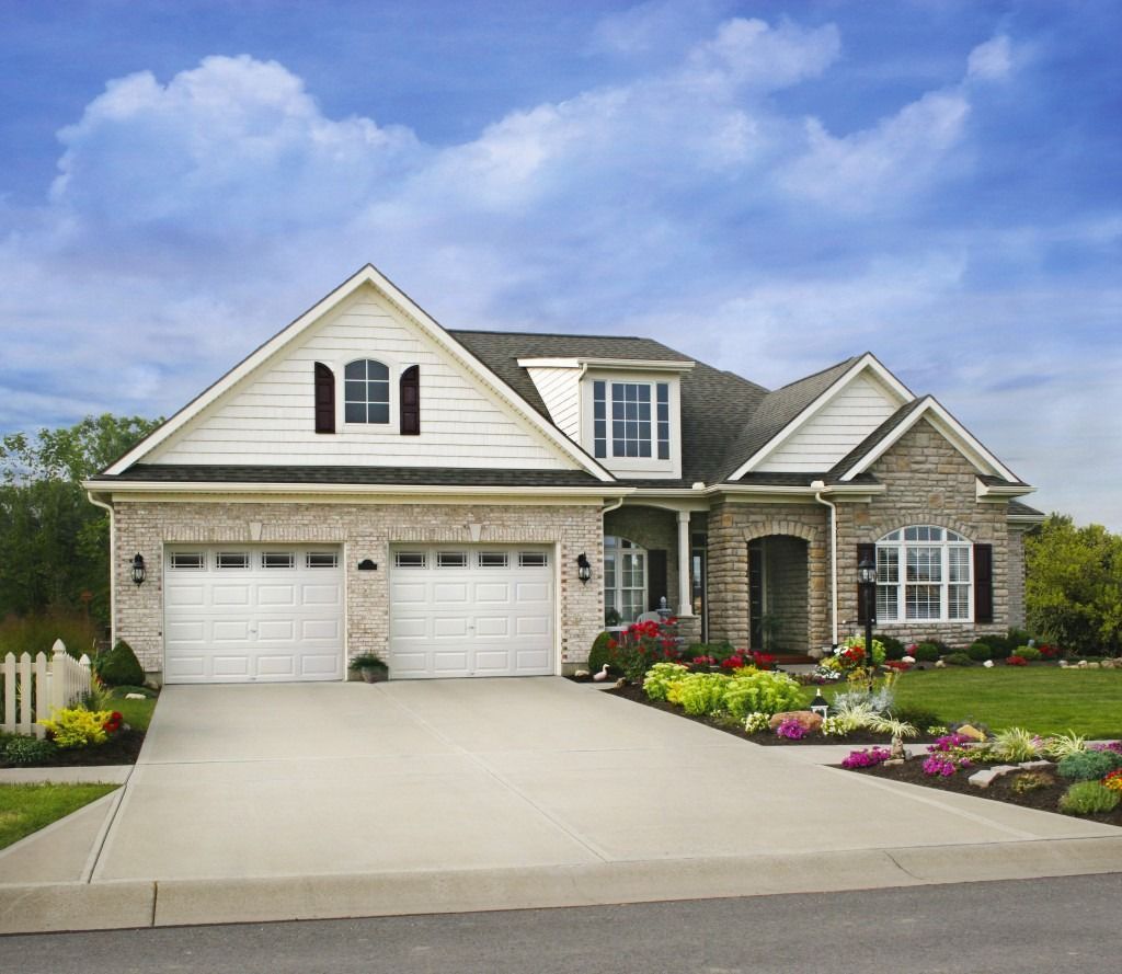 A large house with a concrete driveway in front of it