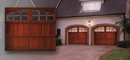 A house with two wooden garage doors in front of it.