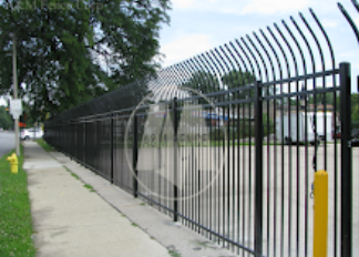 A black metal fence along a sidewalk next to a fire hydrant