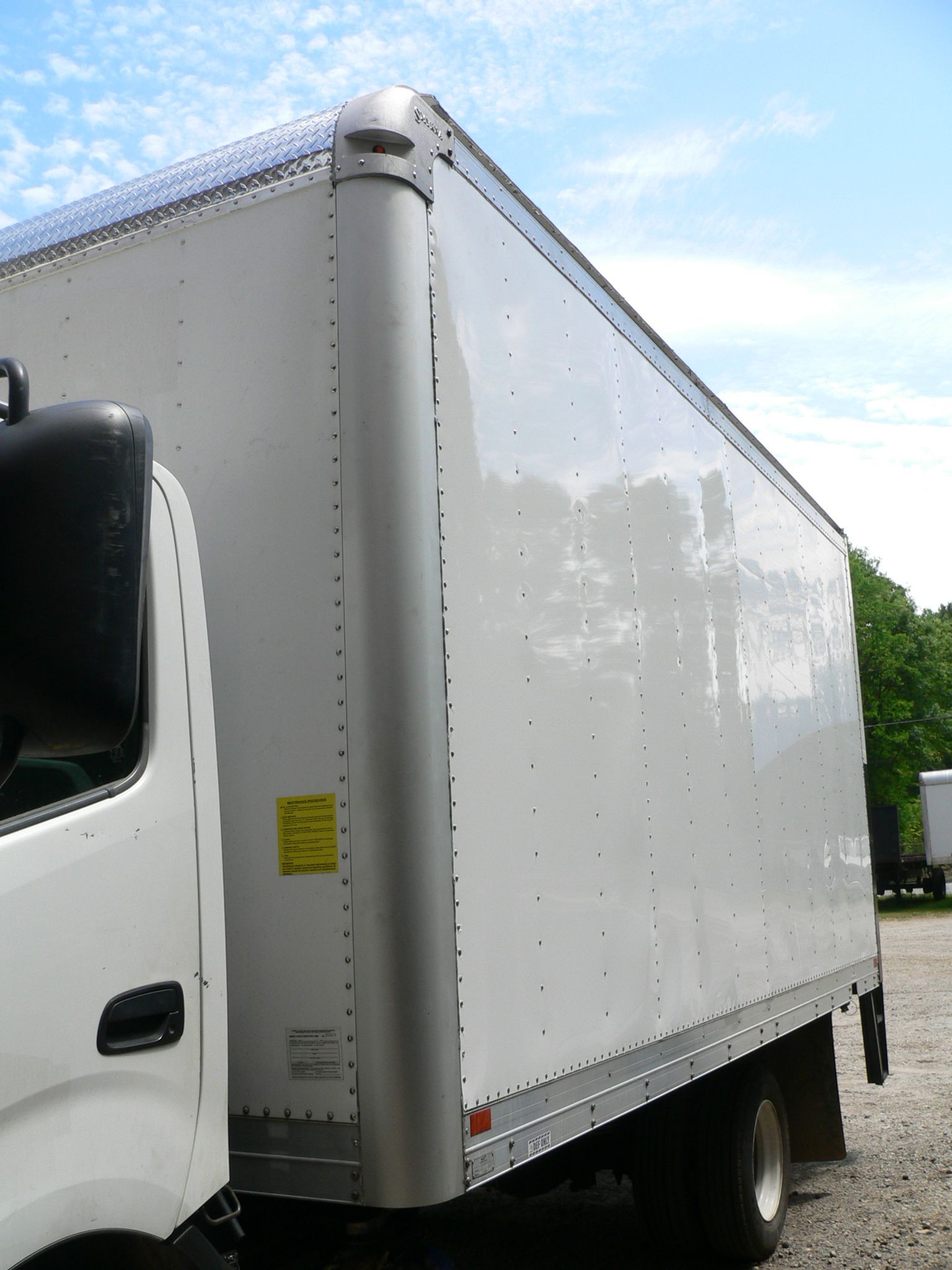 A white truck has a yellow warning sign on the side