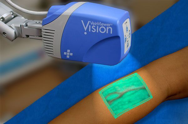 Blue medical device scanning a patient’s arm, highlighting a green area on the skin